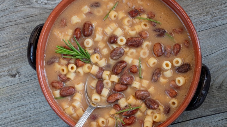 a bowl of soup with ditalini, small tube-shaped pasta, and kidney beans