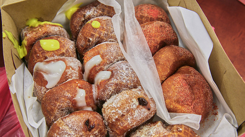 A box of malasadas filled with different fruit fillings