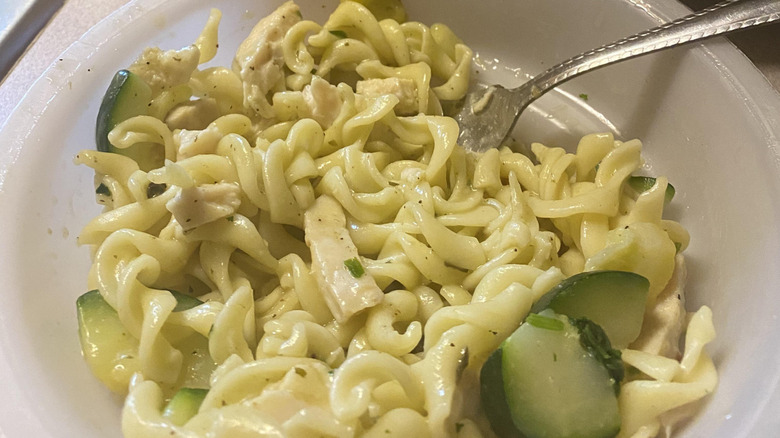 A close up of the cooked Healthy Choice Café Steamers grilled chicken pesto with vegetables dish with a fork sticking out