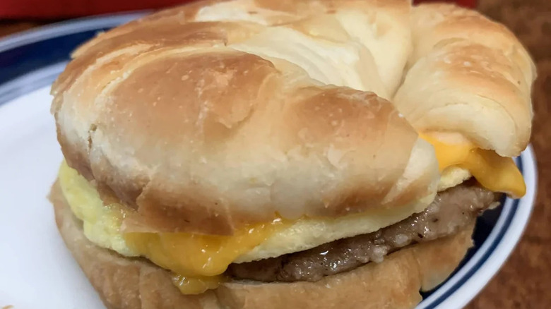 A closeup of a cooked Jimmy Dean sausage, egg and cheese breakfast sandwich on a white plate