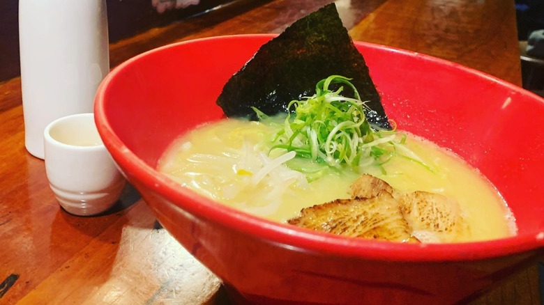 A red bowl of ramen on a counter