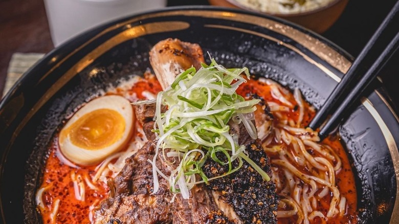 A close up of a bowl of Toyori ramen with chopsticks