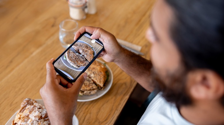 Man taking a picture of his food at a restaurant