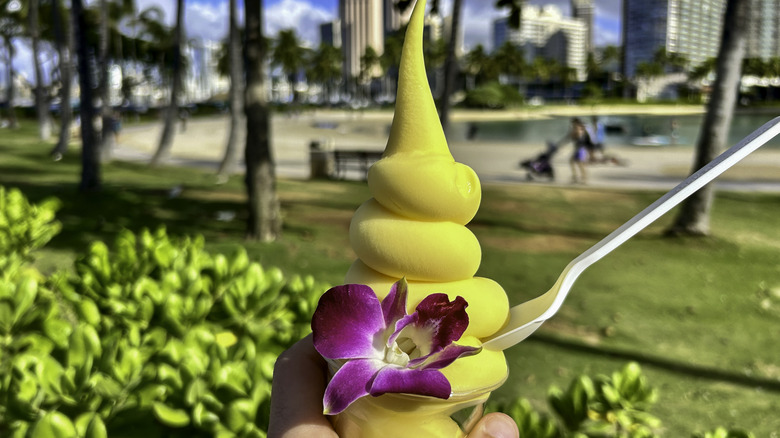 Dole Whip on a plastic white spoon with purple orchid garnish