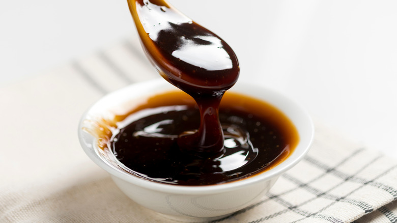 A spoon being dipped into oyster sauce