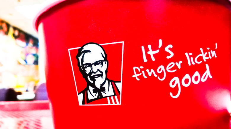 A close up of the KFC slogan It's finger lickin' good on the side of a KFC chicken bucket.