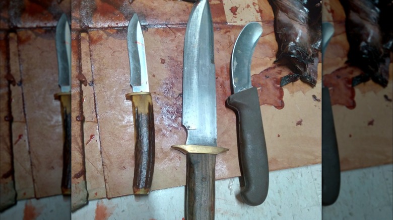 Rustic Butcher and skinning knives with carved meat in background