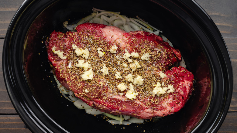 Uncooked beef chuck roast in a slow cooker