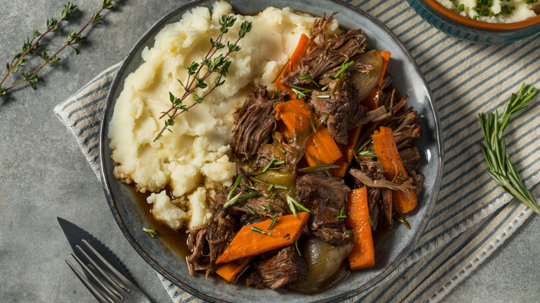 Overhead shot of pot roast plated with vegetables and mashed potatoes