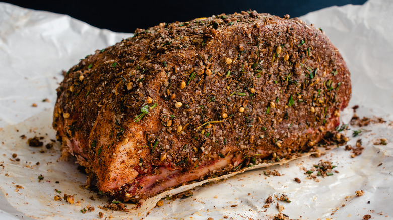 Raw beef roast in an herb rub on parchment paper