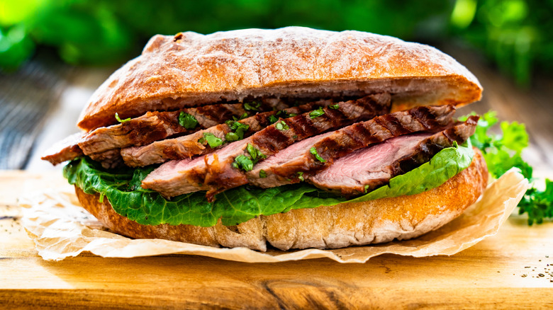 A steak sandwich on a wood board