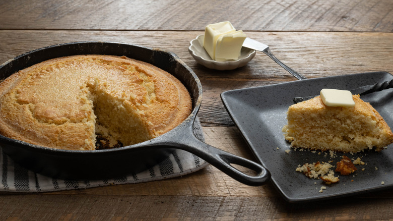 Cornbread in cast iron with slice taken out and butter
