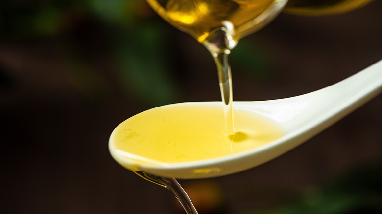 olive oil poured into a white spoon