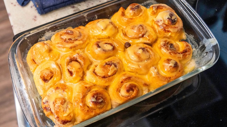 Tightly packed cinnamon rolls in a glass baking dish.