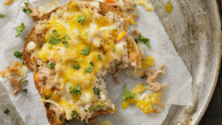 Open-faced tuna melt with bite taken out on butcher paper