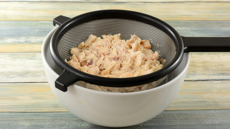 Tuna in strainer over bowl