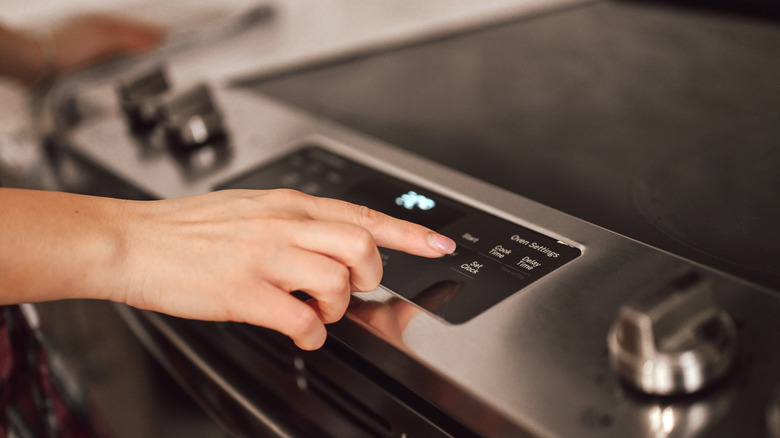 Woman adjusting stove setting