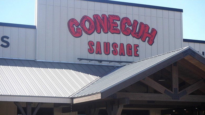 The iconic Conecuh Sausage Company storefront featuring its bold red signage, a popular stop for travelers and food lovers in the South