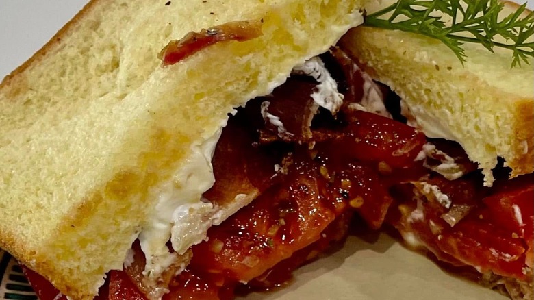 Slocomb tomato sandwich with parsley sprig on top as garnish