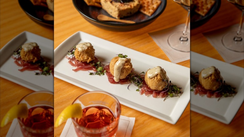 Sazerac cocktail and a plate of blue crab beignets