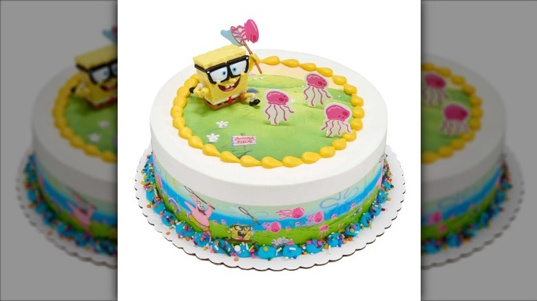 A round layer cake decorated with a figure of SpongeBob SquarePants chasing jellyfish