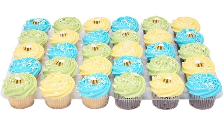 Cupcakes with yellow, blue, and green frosting and bee-shaped decorations.