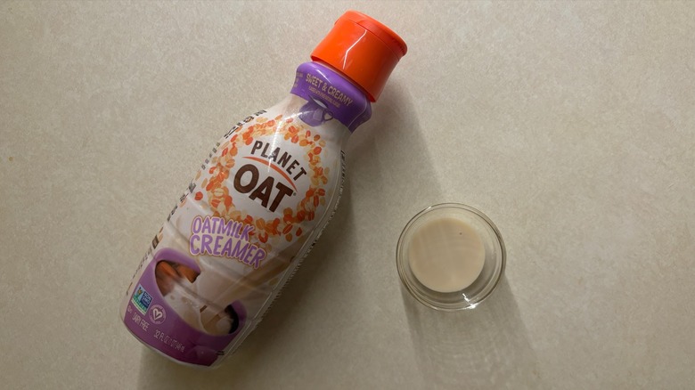 Planet Oat Sweet & Creamy Oatmilk Creamer bottle and creamer in glass ramekin on table