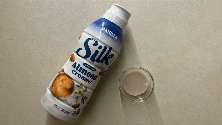 Silk Vanilla Dairy-Free Almond Coffee Creamer bottle and creamer in glass ramekin on countertop