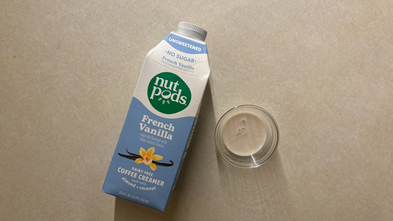 Carton of Nutpods Unsweetened French Vanilla Dairy-Free Coffee Creamer and creamer in glass ramekin on countertop