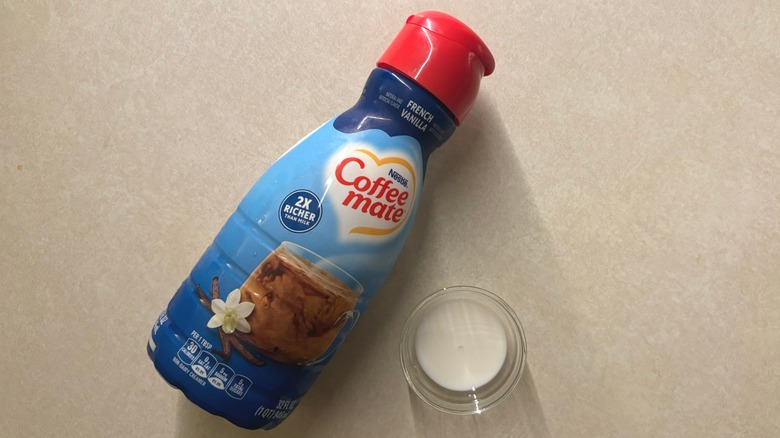 Coffee mate French Vanilla Liquid Non-Dairy Coffee Creamer bottle and creamer in glass ramekin on countertop