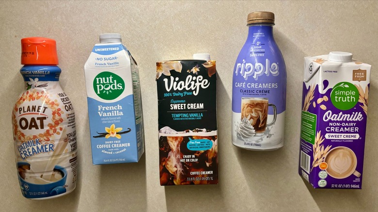 dairy-free creamer cartons arranged on kitchen surface, including brands like Violife, Ripple, and Simple Truth