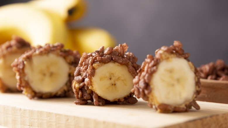 Banana sushi sweet rolls with caramel, peanut butter and chocolate puffed rice. Funny and easy homemade snack for kids and adults.