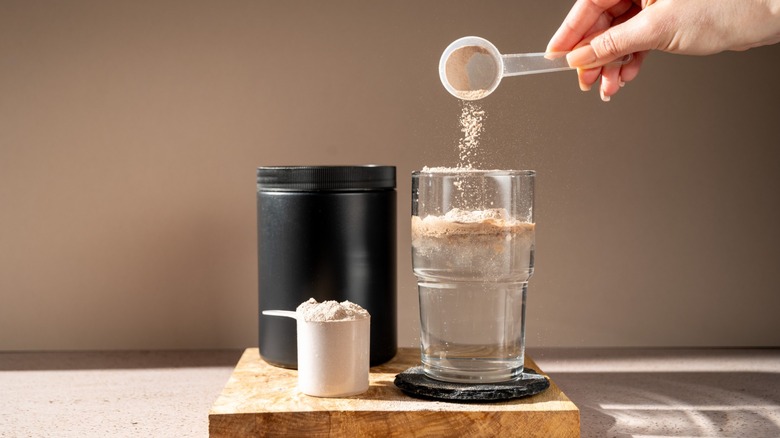 Protein shake and chocolate protein powder in a scoop, Sports nutrition.