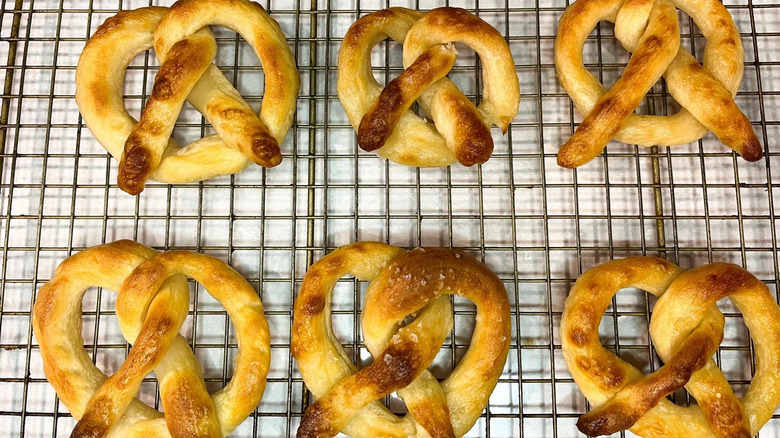 Two rows of pretzels made from leftover gluten free pizza dough rest on a wire rack.