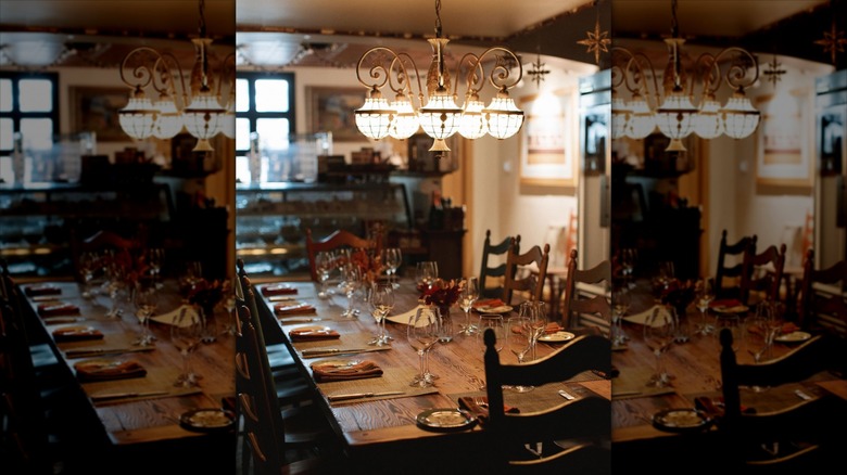 Interior dining area with one long wooden table and chairs, and hanging chandelier at Talula's Table in Kennett Square, PA 