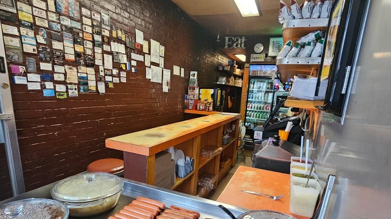 The empty interior of The Squeeze-In in Sunbury, Pennsylvania, showing a bar top next to hot dogs cooking