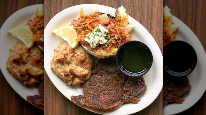 The steak from Hoss's Steak and Seahouse served with a baked potato and biscuit.