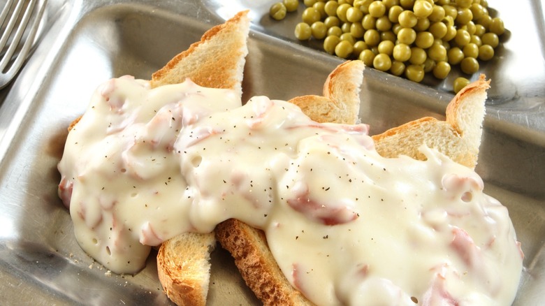 Toast with chipped beef and cream on a metal tin plate