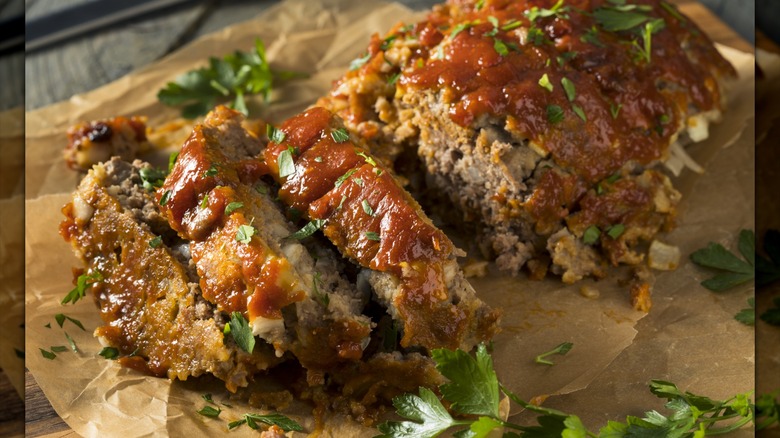 Sliced meatloaf with bacon and garnished with green herbs