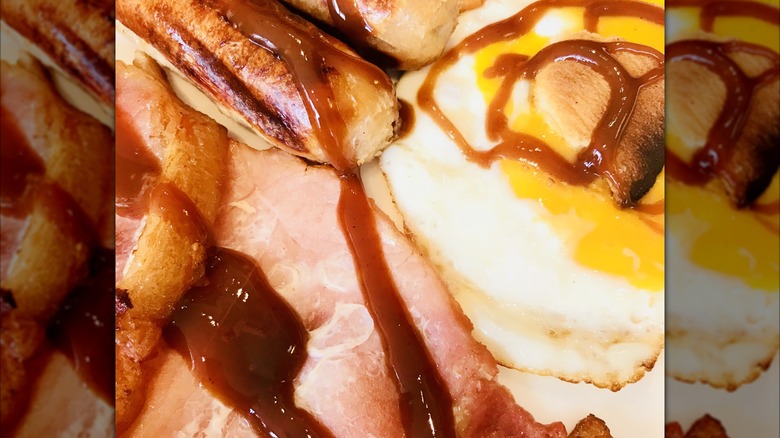 A close-up of brown sauce on an English breakfast platter