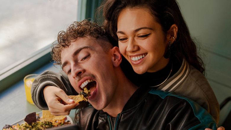 Young couple eating playfully