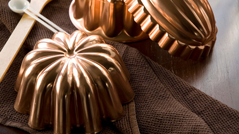 Three copper jelly molds rest on a table