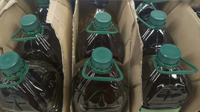 Olive oil bottles in a cardboard box at a grocery store