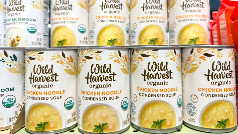Jars of condensed organic chicken noodle soup stacked on store shelf