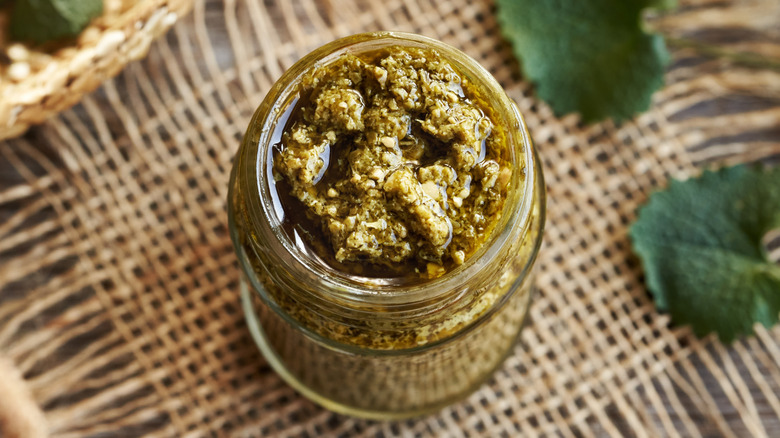 Top view of dull green jar of basil pesto