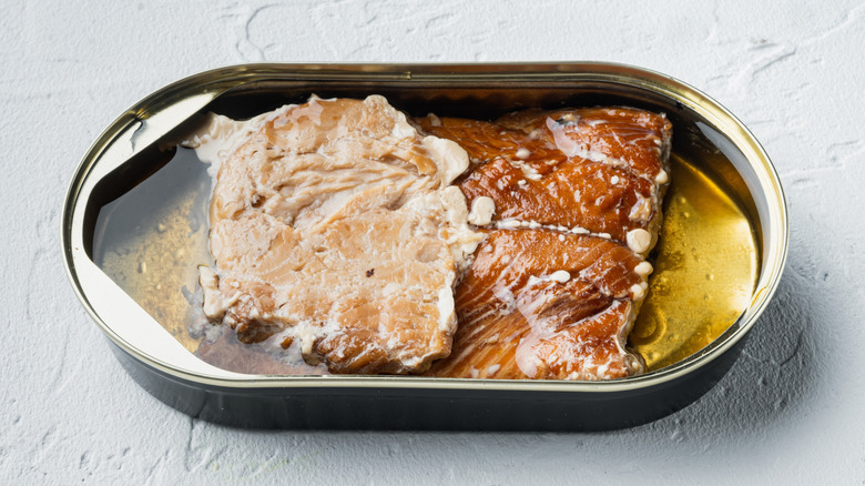 Top view of open can of smoked salmon in oil