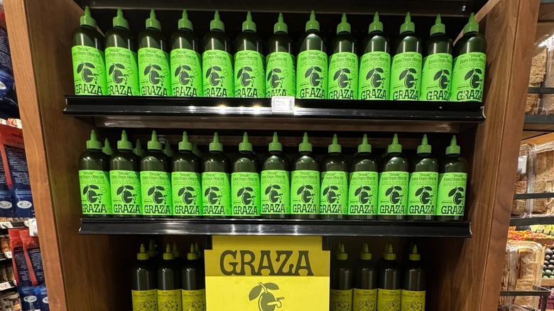shelves of graza olive oil in plastic squeeze bottles at the grocery store