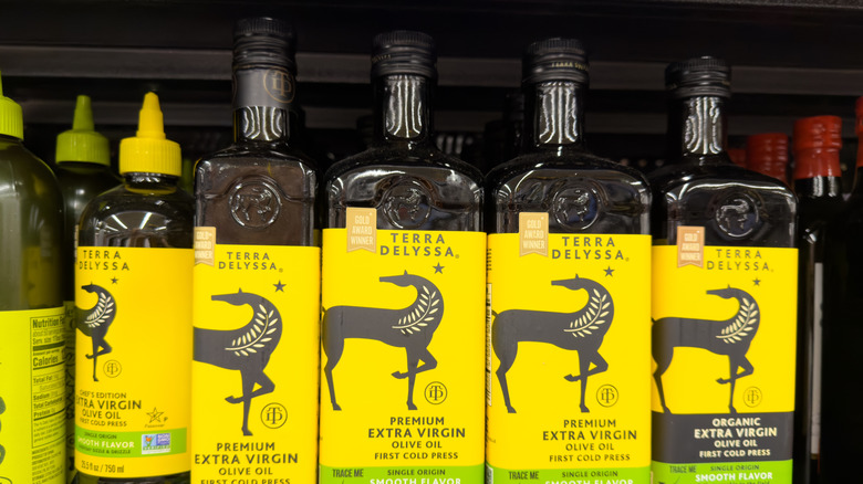 five bottles of terra delyssa olive oil on the shelf at the store