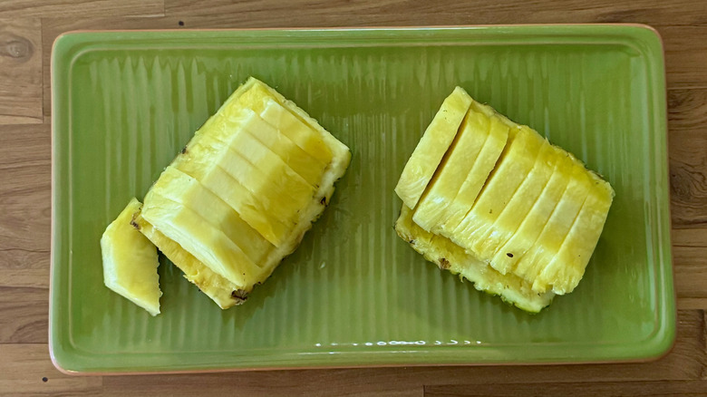 Wedges of pineapple on a green, rectangular serving platter