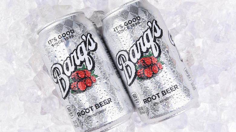Two cans of Barq's Root Beer resting on a large pile of ice